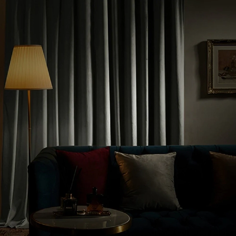 Closed dark gray soundproof curtain behind a couch.