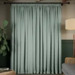 Closed light sage soundproof curtain covering a window.