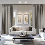 Gray soundproof curtains frame sofa and two windows.