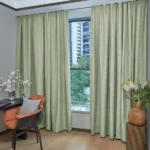 Light green soundproof curtains framing city view window.